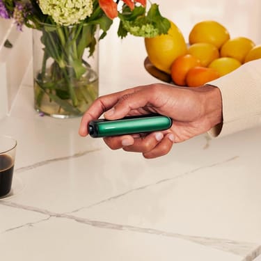 Roka tur Ploom AURA ierīci ar Amazon Green priekšējo paneli