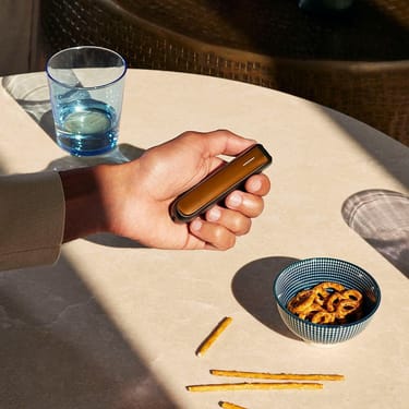 Roka tur Ploom AURA ierīci ar Mango Sorbet priekšējo paneli
