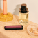 Ploom AURA priekšējais panelis Dark Orchid piestiprināts pie ierīces uz kosmētikas galdiņa